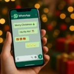 Smartphone affichant des SMS de Joyeux Noël 2025 sur écran WhatsApp avec sapin et cadeaux en arrière-plan